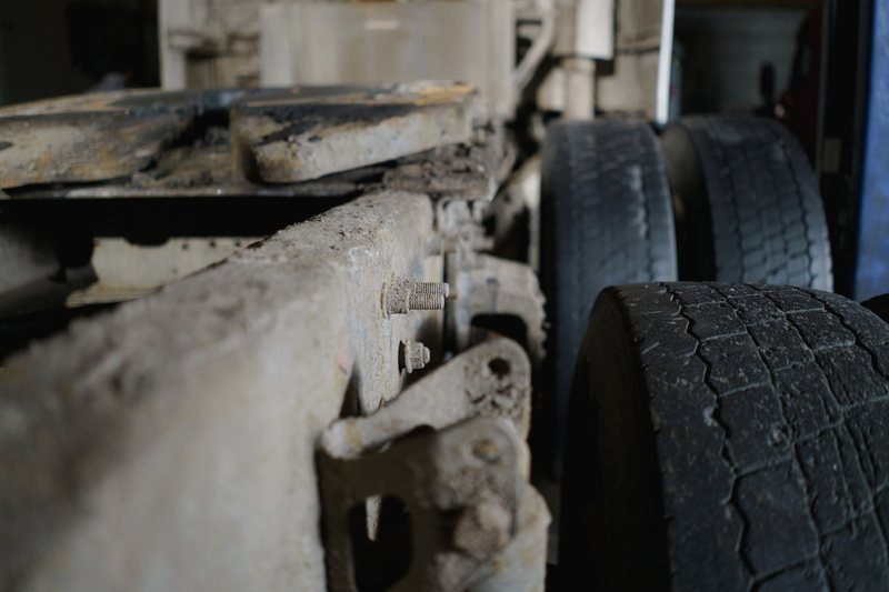 Close view of a heavy truck frame rail and drive tires.